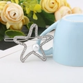 Close-up of silver star hair clip with crystals and pearl by a blue coffee cup - Thick Silver / Style Five (B8102)