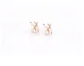Detailed view of elegant gold X-shaped branch earrings with three white round pearls each - Gold