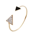 Detail van een gouden open armband met geometrische driehoekige marmeren inleg - Goud (K5505)