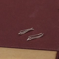 Silver leaf shape ear climbers with wheat ear design on a dark red jewelry box lid - Silver