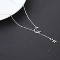Minimalistische silberne Halskette mit Mond- und Sternanhänger auf kontrastreichem Hintergrund - Silber