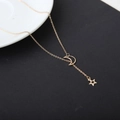 Makro-Detail der vergoldeten Mond- und Sternanhänger an einer feinen Gliederkette - Gold