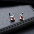 Détail macro de boucles d'oreilles étoile en losange avec zircon rouge et métal argenté - Argent-Rouge