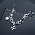 Detail of a dual-layer titanium steel bracelet with heart and letter M pendants on black leather - Letter M Style (S536-A)