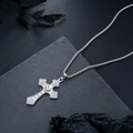 Detalle del collar de cruz plateada con motivo de corazón sobre fondo de piedra - Estilo de Cruz / Estilo de Cadena Larga / Plata Antigua