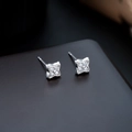 Close-up of four-leaf clover silver stud earrings featuring sparkling cubic zirconia stones - Silver