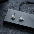Detail van zilveren kruis oorknoppen met zirkonia op een luxe zwarte lederen achtergrond - Kruis Stijl (X1095-A) / Zilver