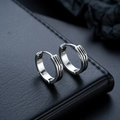 Detailed view of silver hoop earrings with black wave grooves on dark leather - Abyss Style (X570-A)