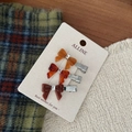 Close-up of three amber-textured resin bow hair clips with crystal centers on card - Brown Rhinestone Bow Clear Side Clip