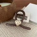Detail of a brown resin hair claw clip with a cream polka dot heart on a display card - Heart Polka Dot Y Claw