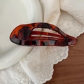 Detail view of large tortoise shell hair claw with hollow crescent design and anti-slip teeth - Glossy Tortoiseshell