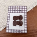 Vue détaillée de deux barrettes nœud marron avec gravure WOO HOO sur une carte - Chocolat Nœud