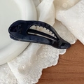Macro detail of glossy dark blue hair claw clip with cutout design on lace background - Haze Blue
