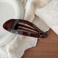 Close-up of elegant tortoise shell pattern hair claw on vintage lace and ceramic plate - Cherry Red