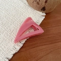 Détail d'une pince à cheveux triangulaire rose sur un fond de table en bois rustique - Triangle Oblique (Rose Prune)