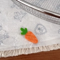 Vue détaillée d'une pince à cheveux carotte en acétate avec feuilles vertes sur papier - Orange