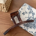 Detalle de una pinza de pelo grande de carey sobre un fondo de tela con textura vintage - Estilo Leopardo Claro Forma Ji