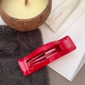 Detailed view of a bright red rectangular hollow hair claw clip on a lifestyle background - Red