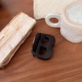 Détail d'une pince à cheveux noire en forme de B sur une table en bois rustique - Chocolat - Lettre B (Env. 7cm)