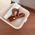 Close-up of caramel brown bow-shaped hair claw clip in an elegant gift box setting - Straight Bow Claw Clip / Approx. 10cm