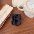 Gros plan d'une pince à cheveux noire brillante en forme de B sur fond minimaliste - Bleu Foncé - Lettre B (Env. 7cm)