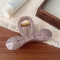 Detailaanzicht van een elegante mauve vlinder haarklem met een gouden metalen veer - Steengrijs Strik