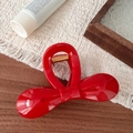 Macro view of a 10.5cm red bow hair claw clip with glossy resin and gold spring details - Red Bowknot