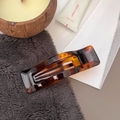 Detailed view of rectangular tortoiseshell acetate hair clip on premium velvet surface - Bright French