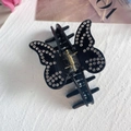 Detailansicht der eleganten schwarzen Schmetterling-Haarklammer mit glänzenden Strasssteinen - Schwarz