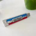 Detail der Zahnpasta-förmigen Acryl-Haarspange mit kreativer Aufschrift auf weißem Grund - Zahnpasta-Entenschnabelclip