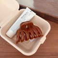 Elegant amber-toned pumpkin hair claw clip with a glossy finish in a warm lifestyle setting - Pumpkin Claw Clip / Standard Spec