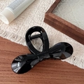 Elegant black glossy bow hair claw clip made of resin on a warm wooden background - Glossy Black Bowknot