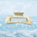Detail of a rectangular acetate hair claw clip with cream marble pattern on a bright sky backdrop - Cheese Jelly