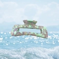 Macro view of floral acetate claw clip with light green and purple splash patterns - Taro Purple
