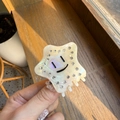 Dettaglio del mollettone a stella in acetato con strass e faccina sotto la luce naturale - Bianco Perla
