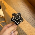 Detalle de pinza para el pelo estrella negra de acetato con pedrería y cara sonriente - Negro