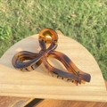 Large tortoiseshell bow hair claw clip with gold spring on a wooden display stand - Approx 11cm / Glossy Light Tortoiseshell Ribbon Bow