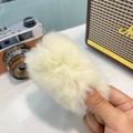 Détail d'une pince à cheveux en peluche blanc crème avec une texture de fourrure douce - Blanc