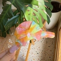 Gros plan d'une pince à cheveux en acétate avec un nœud aux reflets irisés colorés - Orange Jaune Français Multicolore