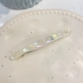 Nahaufnahme der cremefarbenen Acetat-Haarspange mit glitzerndem Strassstein und Logo-Detail - Strass Federclip / Weißes Perlmutt