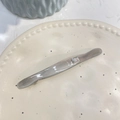 Détail d'une barrette à cheveux en acétate gris avec cristal carré et lettrage doré - Pince à Ressort Strass / Gris Élégant