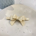Close-up of a creamy white acetate bow hair clip on a minimalist ceramic jewelry tray - Crooked 3D Bow (Approx 9cm) / Off-white