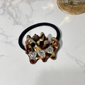 Detailed view of acetate cat hair tie with rhinestone hearts on white marble - Hair Tie / Brown