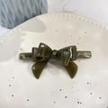 Detailansicht der dunkelgrünen Acetat-Schleifen-Haarspange mit goldenem Logo auf Tablett - Schiefer 3D-Bogen (ca. 9cm) / Grün Gelee