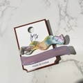 Close-up of wavy pearlescent and purple matte hair clips on original white card - Elegant Purple