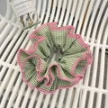 Nahaufnahme von grünem Karo-Haargummi mit rosa Spitzenborte und plissierter Textur - Grünes Karo Rosa Rand Scrunchie