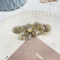 Dettaglio del fermaglio per capelli a fiore in acetato con trama marmorea e cristallo - Molletta a Becco d'Anatra Farfalla con Strass / Beige Grigio Traslucido