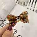 Detail of star bow hair clip with tortoiseshell finish and colorful woven edges - Blue Floral Tortoiseshell