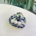Detail view of acetate hair claw with green marble texture and three white pearls - Blue Patterned