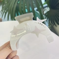 Dettaglio del fermaglio a luna in acetato con motivi a stella e strass brillanti - Bianco Elegante